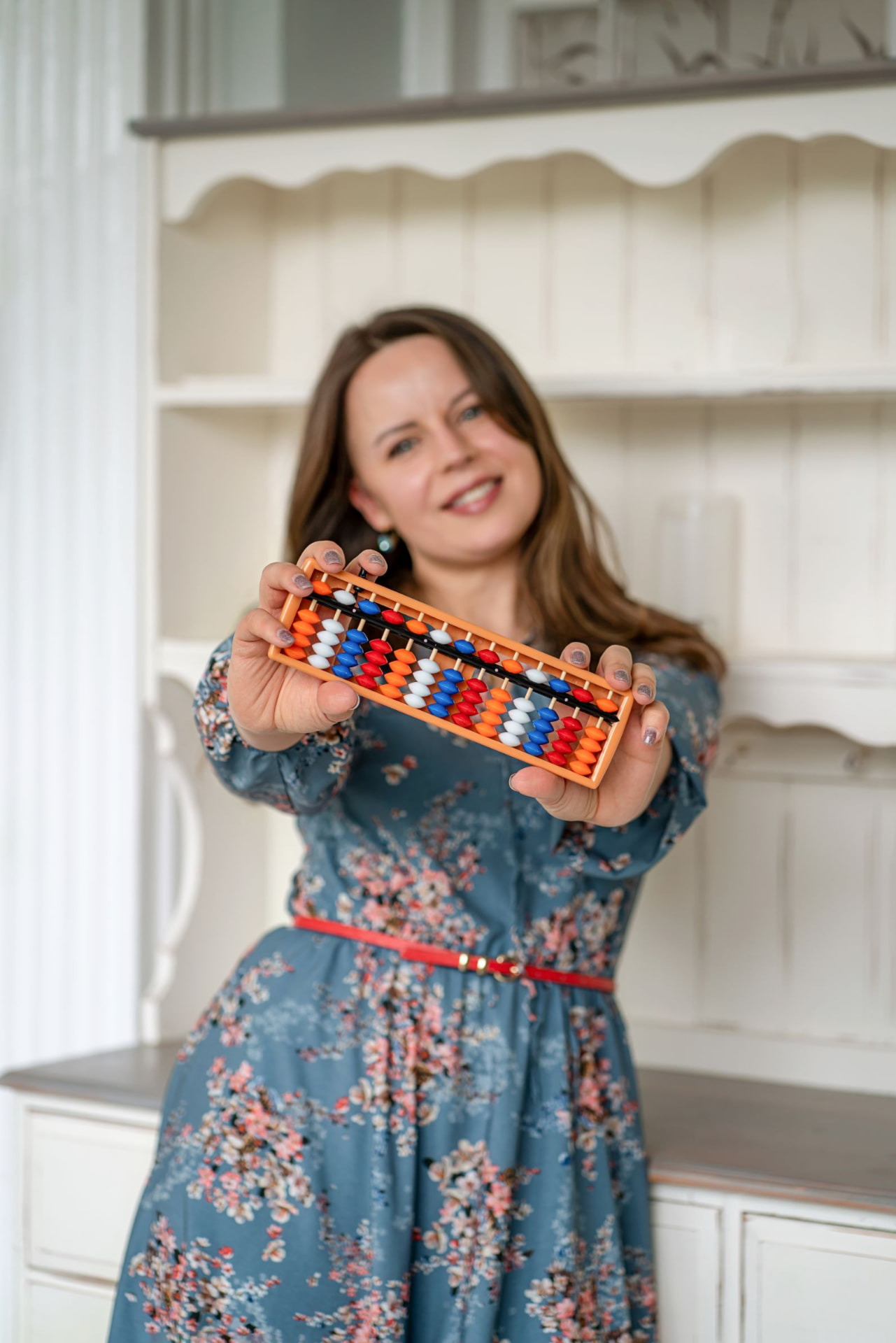 An INDIGO trainer holding up an abacus